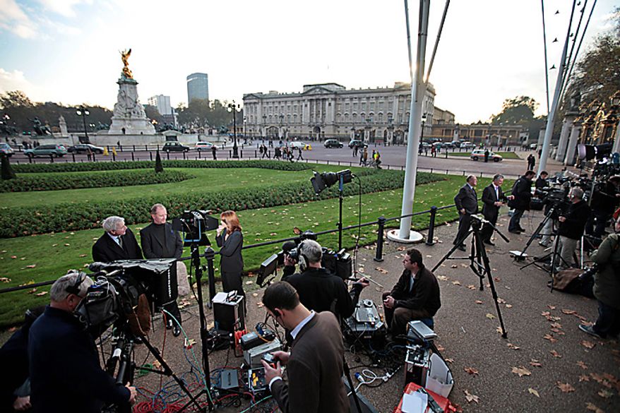 Members of the media work on the story of Britain's Prince William engagement, across the street from Buckingham Palace, background, in central London, Tuesday, Nov. 16, 2010. Britain's Prince William, who is second in line to the throne, and girlfriend Kate Middleton are engaged and will marry next spring or summer in London _ a royal wedding that Britons have been eagerly awaiting for years. The announcement Tuesday by royal officials ends an on-again, off-again romance that began after the two met more than eight years ago as students at the University of St. Andrews in Scotland. Prince William turned 28 in June and recently completed training a Royal Air Force search and rescue pilot.(AP Photo/Lefteris Pitarakis)