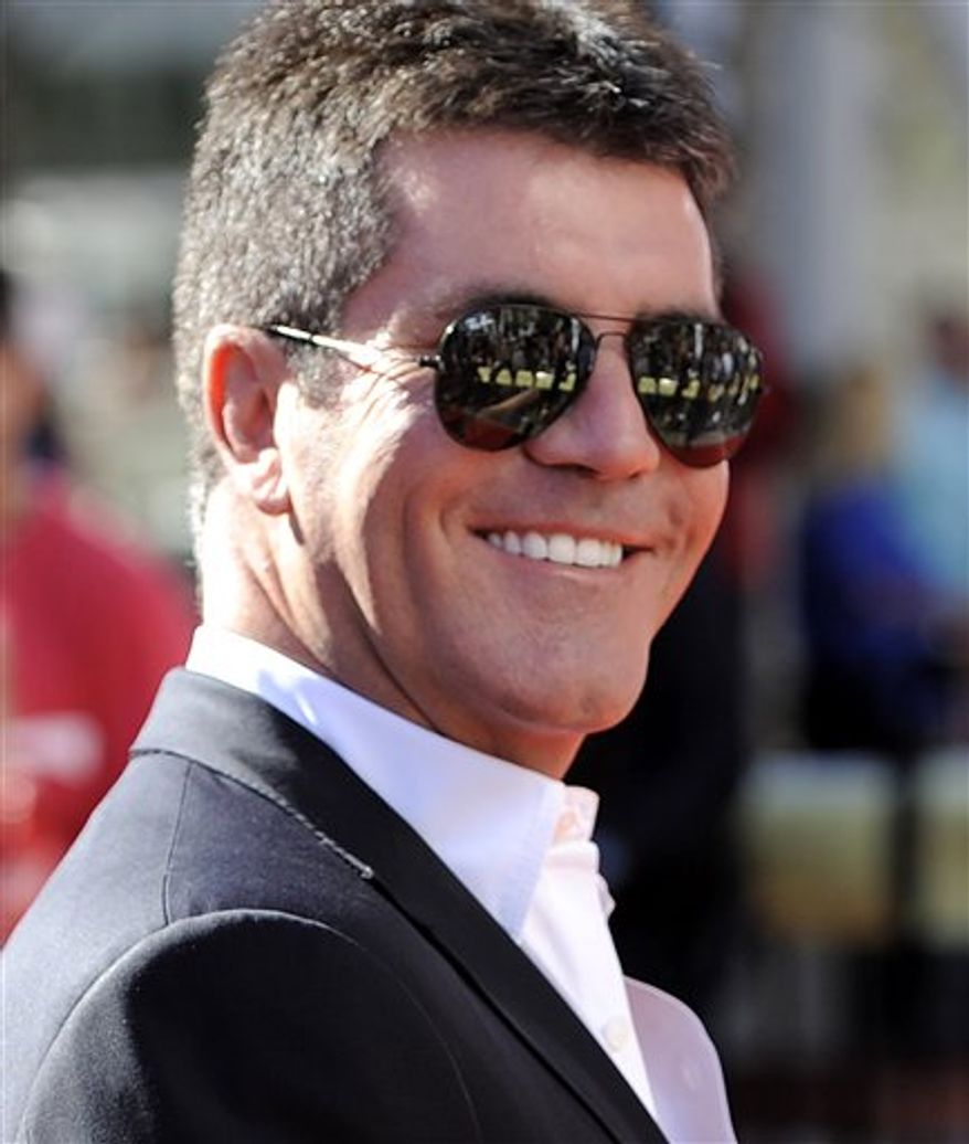Simon Cowell poses with his award at the 38th International Emmy Awards, Monday, Nov. 22, 2010, in New York. (AP Photo/Louis Lanzano)