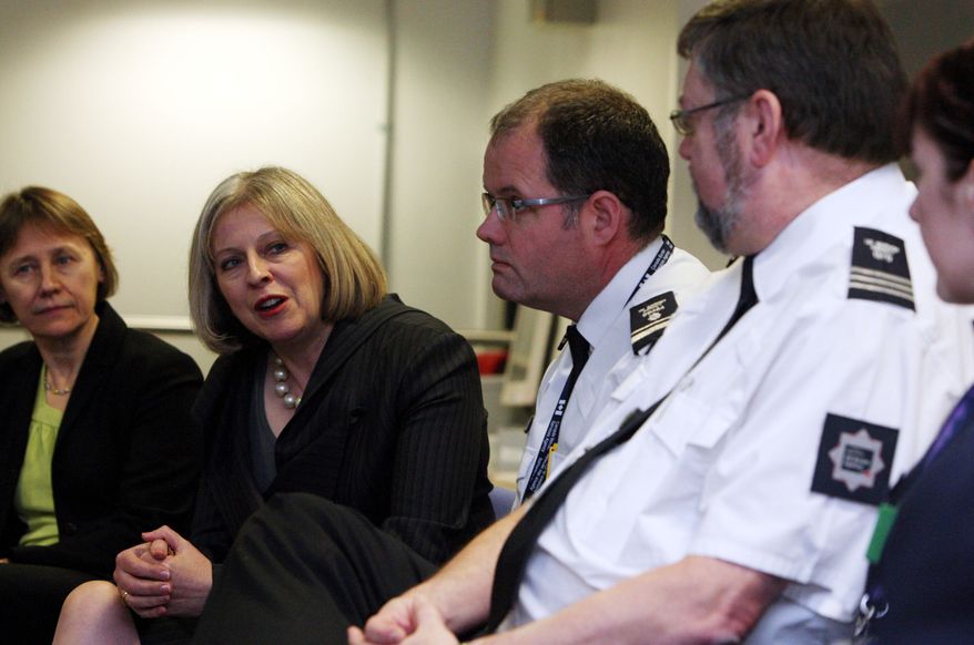Home Secretary Theresa May, second left, visit the British Border Agency staff at Terminal 5 of Heathrow Airport, London, where they were shown differences between fake and real passports Tuesday Nov. 23, 2010. Britain's Home Office says it will be announcing the country's permanent immigration quota --- a new limit intended to dramatically reduce the number of non-EU nationals permitted to work in Britain. (AP Photo/ Steve Parsons, Pool)