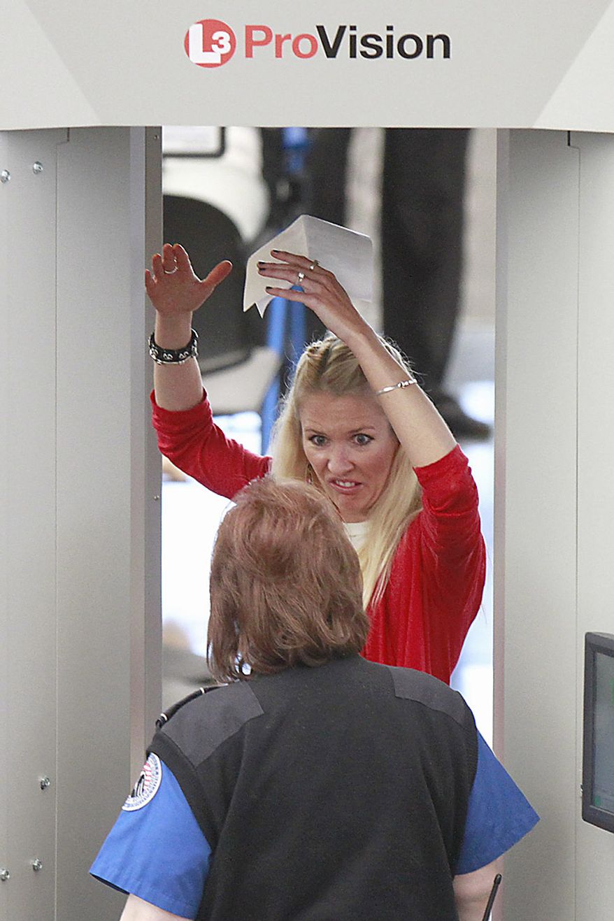 A woman reacts to a TSA agent while having her body scanned during the busiest travel weekend of the year at Denver International Airport, Wednesday, Nov. 24, 2010. (AP Photo/Barry Gutierrez)