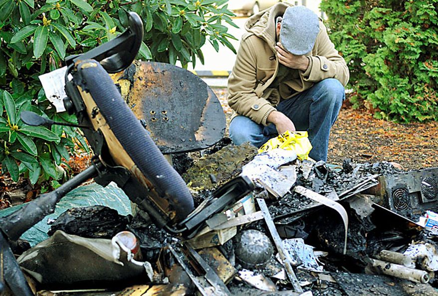 Ahson Saeed, of Corvallis, Ore., reacts over a pile of burnt debris pulled from a local mosque in Corvallis, Ore. Sunday, Nov. 28, 2010 where an alleged arsonist set a fire in the early morning hours. Anger on Sunday over a Somali-born teen's failed plan to blow up a van full of explosives during Portland's Christmas tree lighting ceremony apparently erupted in arson on Sunday when a fire damaged the Islamic center once frequented by the suspect. Police don't know who started the blaze or exactly why, but they believe the mosque was targeted because terror suspect Mohamed Osman Mohamud, 19, occasionally worshipped there. (AP Photo/Corvallis Gazette-Times, Jesse Skoubo)