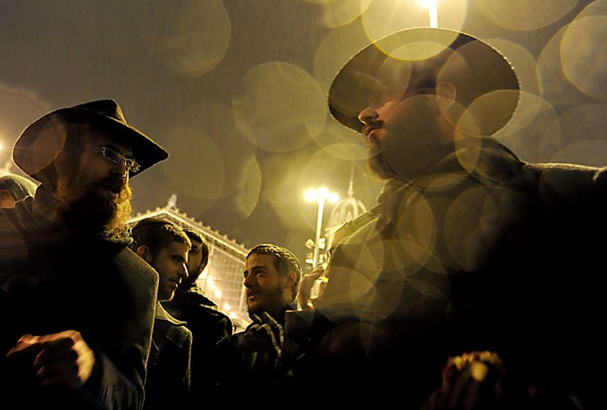Members of the Hungarian Orthodox Jewish community dance at the beginning of the Hanukkah Festival in downtown Budapest, Hungary, Wednesday, Dec 1, 2010. The Hanukkah Festival, also known as the Festival of Lights, is lasting eight days and it's commemorating the rededication of the Second Temple in 165 BC at the time of the Maccabee rebellion. (AP Photo/Bela Szandelszky)