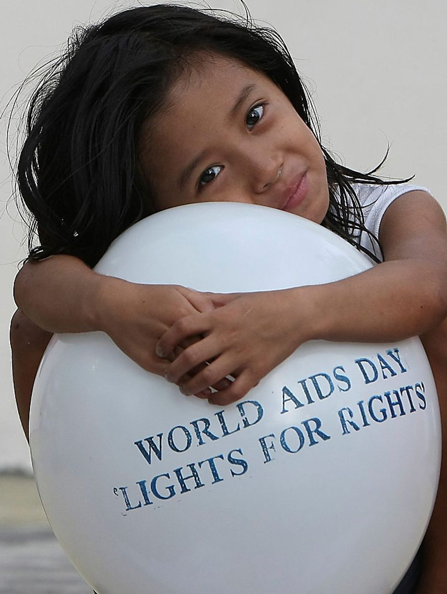 A little girl embraces a balloon as Filipino health workers and volunteers, not in the photo, mark World AIDS Day in Manila, Philippines Wednesday, Dec. 1, 2010. Citing 2008 figures, WHO (World Health Organization) said some 33.4 million are living with HIV, with 2.7 million newly infected with the virus and 2 million dying of AIDS. The Philippines has a low prevalence of HIV infection with 5,729 cases, according to the data from the Department of Health. (AP Photo/Bullit Marquez)