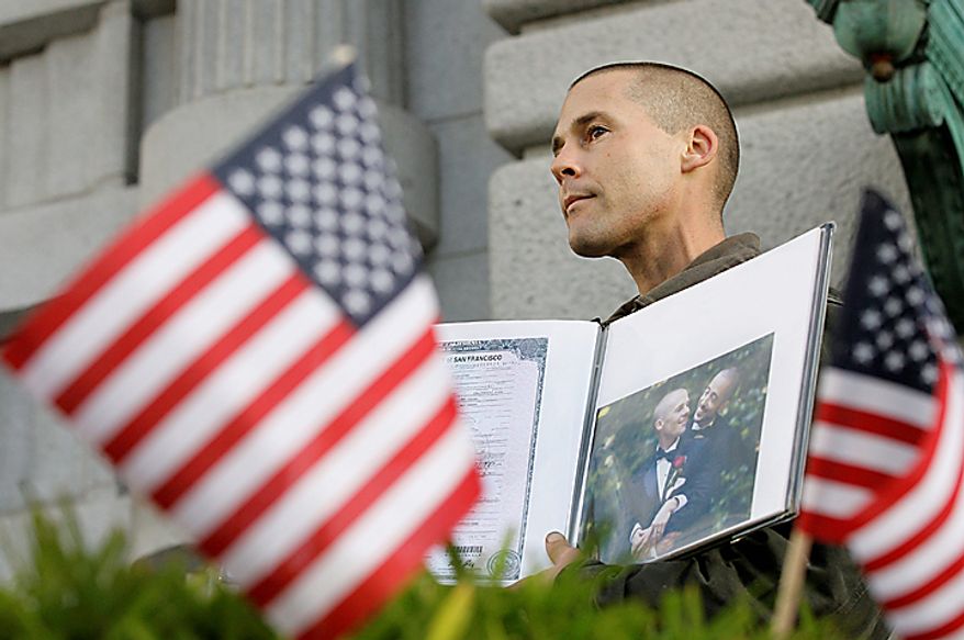 Frank Capley-Alfano holds up a book with a photo of him and his husband Joseph outside the courthouse before a hearing in the Ninth Circuit Court of Appeals, Monday, Dec. 6, 2010, in San Francisco. The federal appeals court in San Francisco began to hear arguments Monday about the voter-approved ban known as Proposition 8. A trial court judge overturned the measure as a violation of gay Californians' civil rights in August. (AP Photo/Jeff Chiu)