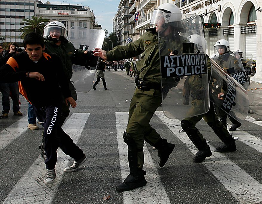Protesters clash with riot police during a rally in Athens on Monday, Dec. 6, 2010. Youths hurled rocks and oranges at a government building in central Athens during a student protest to mark two years since the fatal police shooting of a teenage boy that sparked Greece's worst riots in decades. Police closed roads and deployed several thousand officers around the city but maintained a minimal presence at the site where some 1,500 students gathered outside Athens University's main buildings. (AP Photo/Alkis Konstantinidis)