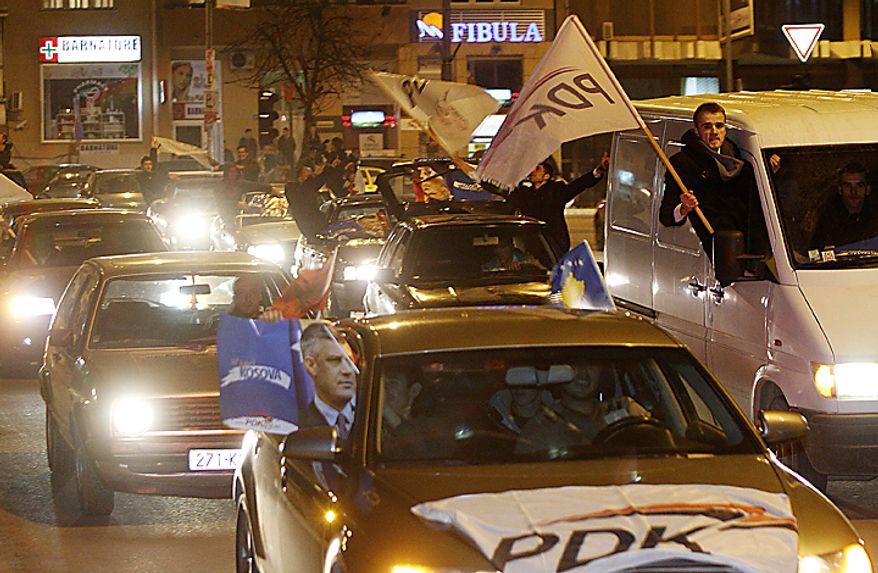 Supporters of the Democratic Party of Kosovo (PDK) celebrate the party's victory in Pristina, Kosovo, on Sunday, Dec. 12, 2010. Incumbent Prime Minister Hashim Thaci, seen in photo on poster at left, claimed victory Sunday in Kosovo's first general election since the province declared independence from Serbia, as an independent exit poll showed his Democratic Party of Kosovo 6 percentage points ahead of its rivals. (AP Photo/Visar Kryeziu)