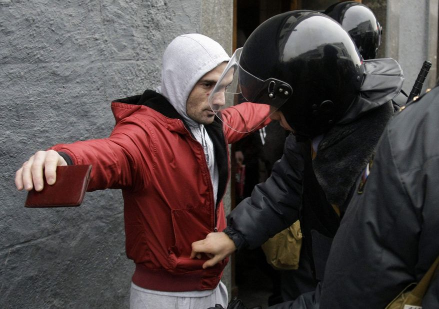 ** FILE ** Riot police officers search a man at a square outside the Kievsky train station, amid fears of a repeat of Saturday's clashes, in Moscow on Wednesday, Dec. 15, 2010. (AP Photo/Mikhail Metzel)