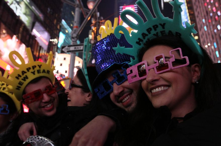 A group of friends pose for photographs as they take part in the New Year's Eve festivities in New York's Times Square on Friday, Dec. 31, 2010. (AP Photo/Tina Fineberg)