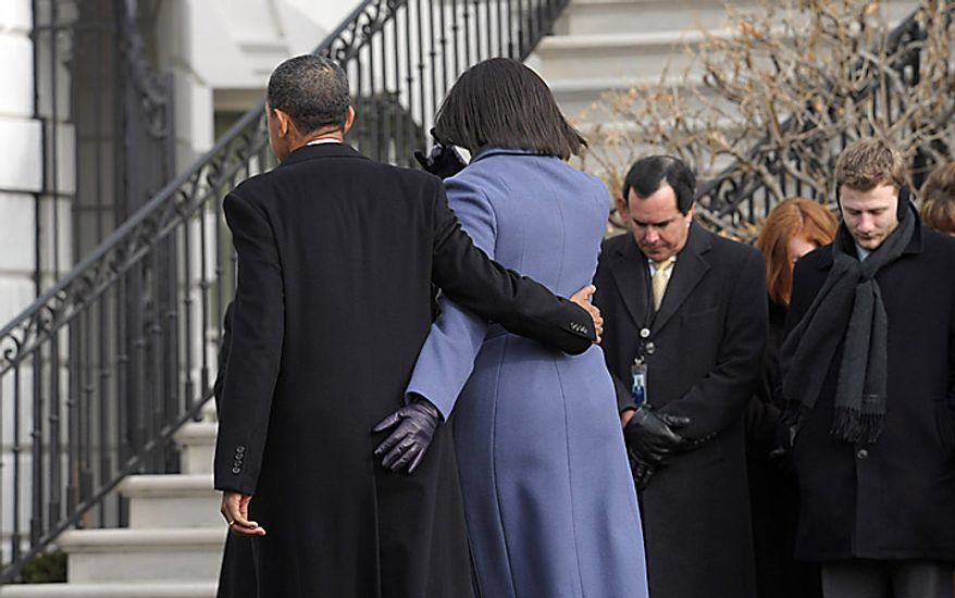 President Barack Obama and first lady Michelle Obama head back into the White House after observing a moment of silence with government employees on South Lawn of the White House in Washington, Monday, Jan. 10, 2011, to honor those who were killed and injured in the shooting in Tucson, Ariz. Rep. Gabrielle Giffords, D-Ariz., is in critical condition after being shot in the head. (AP Photo/Susan Walsh)
