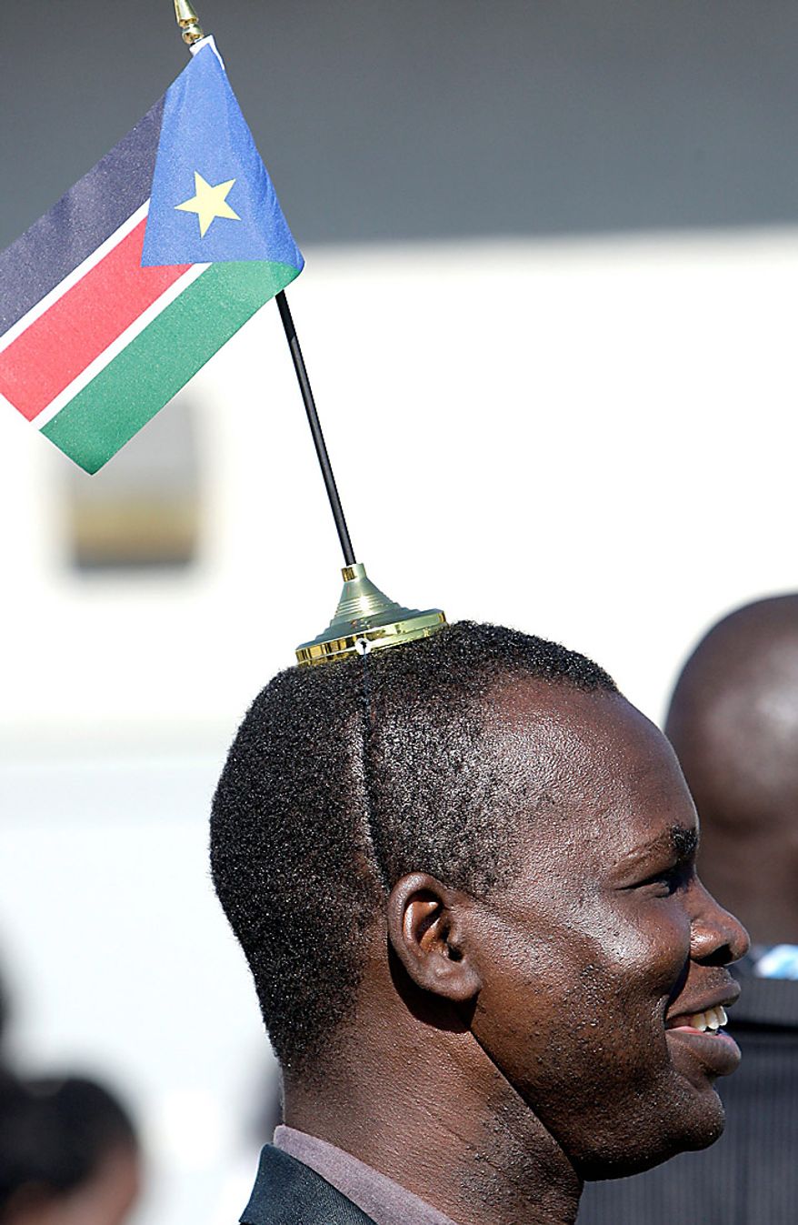 William Obur wears the flag of South Sudan on his head after casting his ballot in the South Sudan referendum election at an out-of-country voting precinct on Sunday, Jan. 9, 2011, in Glendale, Ariz. (AP Photo/Ross D. Franklin)