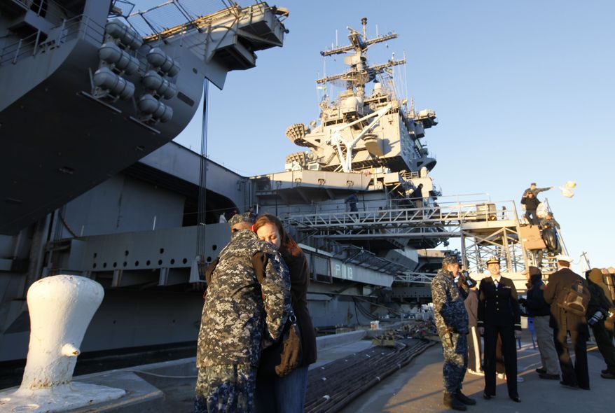 Petty Officer 3rd class Robert Hampton of Newport News, Va., gets a goodbye hug from his wife, Rebecca, as he prepares to deploy on the nuclear powered aircraft carrier USS Enterprise at Naval Station Norfolk in Norfolk, Va., Thursday, Jan. 13, 2011. The USS Enterprise is deploying without its former commander as Navy brass investigates bawdy, sexually themed videos he showed to thousands of crew members. (AP Photo/Steve Helber)