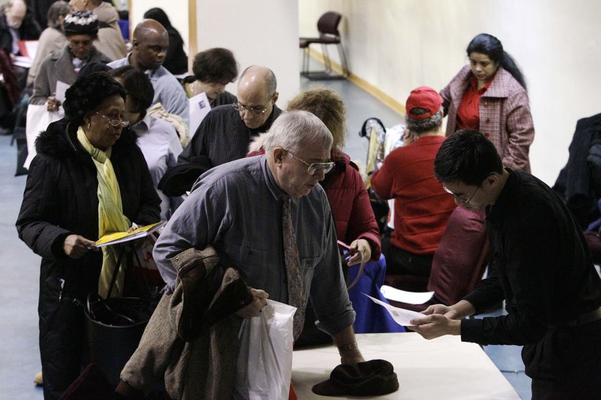 John Pham (right), a program officer with Reserve Inc., reviews the resume of Bob Drake, 63, at an AARP career event aimed at helping older workers improve their job search in New York on Tuesday, Jan. 18, 2011. (AP Photo/Frank Franklin II)