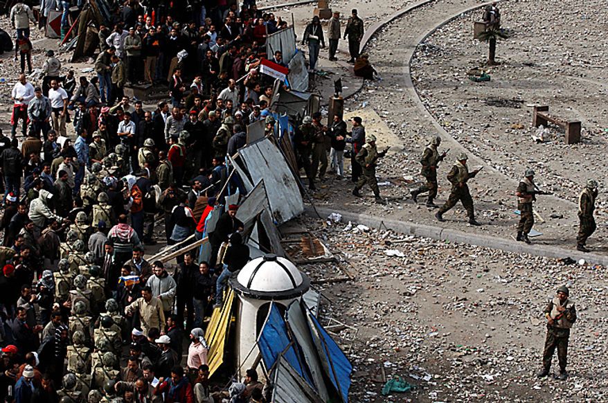 Egyptian army soldiers patrol through anti-government protesters in downtown Cairo Thursday, Feb. 3, 2011. (AP Photo/Khalil Hamra)