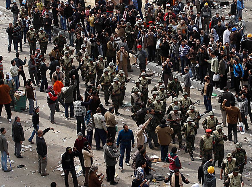 Egyptian army soldiers patrol through anti- government protesters in downtown Cairo Thursday, Feb. 3, 2011. (AP Photo/Khalil Hamra)