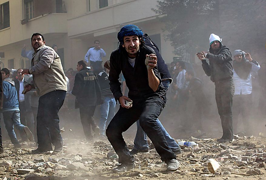 Anti-government protesters throw stones during clashes in Cairo Thursday, Feb. 3, 2011. Another bout of heavy gunfire and clashes erupted Thursday around dusk in the Cairo square at the center of Egypt's anti-government chaos, while new looting and arson spread around the capital. Gangs of thugs supporting President Hosni Mubarak attacked reporters, foreigners, and human rights workers and the army rounded up foreign journalists. (AP Photo/Sebastian Scheiner)
