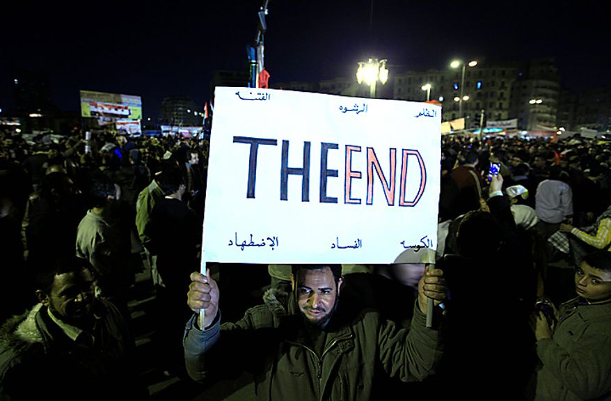 An Egyptian anti-government protester marches with a banner reading "the end" as he celebrates in Tahrir Square in downtown Cairo Thursday, Feb. 10, 2011. Egypt's military announced on national television it had stepped in to secure the country and promised protesters calling for President Hosni Mubarak's ouster that all their demands would soon be met. Tens of thousands of protesters packed in central Tahrir broke into chants of 'We're almost there, we're almost there' and waved V-for-victory signs as thousands more flowed in to join them well after nightfall. (AP Photo/Amr Nabil)