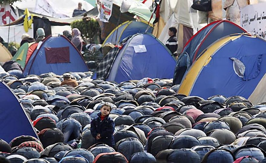 Anti-government protesters pray in Tahrir Square in downtown Cairo, Egypt, Friday, Feb. 11, 2011. The Egyptian government announced later Friday that President Hosni Mubarak has stepped down. (AP Photo/Khalil Hamra)