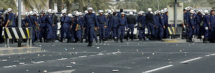 Bahraini riot police seen near Pearl Square during clashes with anti government protesters in capital Manama early Thursday morning, Feb. 17, 2011. Some protesters appeared unbowed as armed patrols prowled neighborhoods and tanks appeared in the streets for the first time Thursday after riot police with tear gas and clubs drove protesters from Pearl Square where they had demanded sweeping political change in this tiny kingdom. Medical officials said four people were killed. (AP Photo/Hassan Ammar)