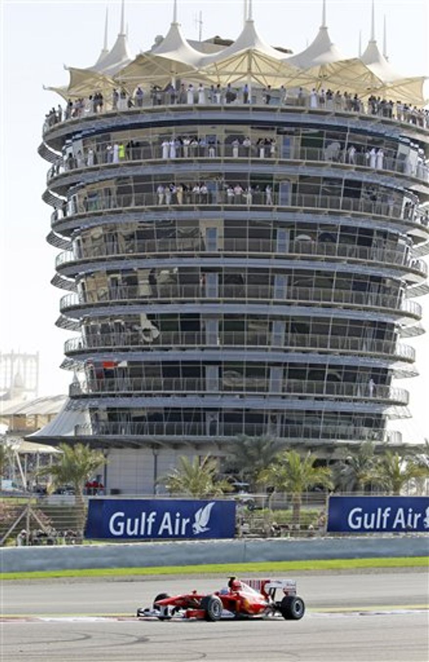 FILE - This is a Sunday, March 14, 2010 file photo of Ferrari driver Fernando Alonso of Spain as he passes the VIP tower during the Bahrain Formula One Grand Prix at the Bahrain International Circuit in Sakhir, Bahrain. Bahrain Grand Prix organizers say the season-opening Formula One race has been called off due to the anti-government protests in the Gulf kingdom. (AP Photo/Ben Curtis, File)