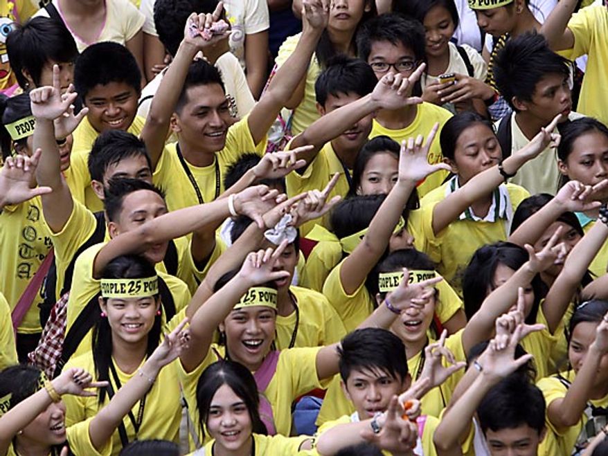 Students flash the "L" sign for Laban or Fight as they join the march celebrating the 25th anniversary of People Power revolution Friday, Feb. 25, 2011, in suburban Pasig City east of Manila, Philippines. The nearly bloodless four-day people power revolution 25 years ago saw the ouster of the late strongman Ferdinand Marcos from 20-year rule and helped install now President Benigno Aquino III's mother Corazon "Cory" Aquino to the presidency.(AP Photo/Pat Roque)