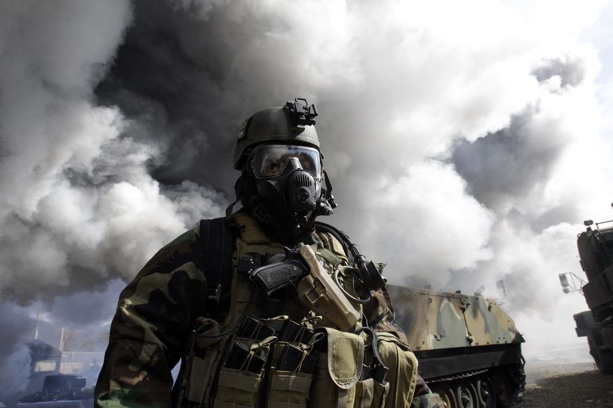 A U.S. soldier from the 2nd Infantry Division wears a gas mask and anti-chemical gear during a joint U.S.-South Korea military drill for chemical, biological, radiological and nuclear detection and response capabilities at Camp Casey in Dongducheon, South Korea, north of Seoul, on Thursday, March 3, 2011. Troops from the two allies kicked off their annual drills Monday, while North Korea slammed the maneuvers as a rehearsal for an invasion of the North that could trigger a nuclear war on the divided peninsula. (AP Photo/Lee Jin-man)