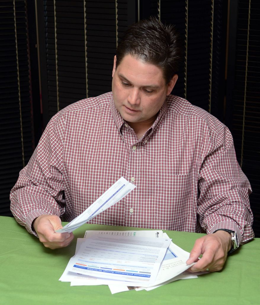 Brett Hacker looks over his 401(k) statements, which show that his retirement account is growing once again after the balance sank when the stock market did. (Associated Press)