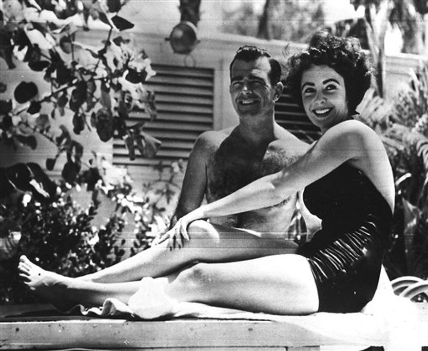 FILE - In this June 7, 1949 file photo, 17-year-old actress Elizabeth Taylor, right, poses with fiance William D. Pawley Jr. at his father's home in Miami Beach, Fla. Over 60 love letters written by the late actress will be put up for auction by RR Auction in Amherst, N.H. The auction house bought the letters two years ago from William Pawley, who was engaged to Taylor for less than a year in 1949. Taylor died Wednesday, March 23, 2011 in Los Angeles of congestive heart failure at age 79. (AP Photo, file)