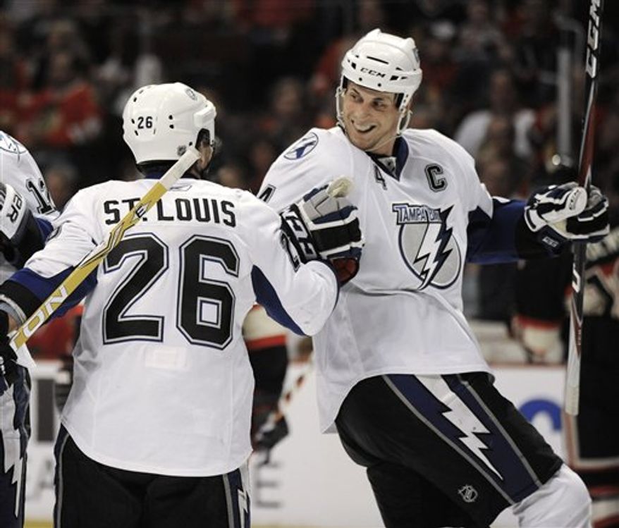 Tampa Bay Lightning's Vincent Lecavalier right, celebrates with teammate Martin St. Louis after scoring against the Chicago Blackhawks in the first period during an NHL hockey game in Chicago, Sunday, April 3, 2011. (AP Photo/Paul Beaty)