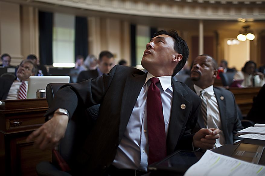Democratic Delegates Mark Keam, left, and Luke Torian, right, react to the scoreboard of votes on governor's budget amendments, on the House floor at the Capitol, in Richmond, Wednesday, April 6, 2011. (Drew Angerer/The Washington Times)