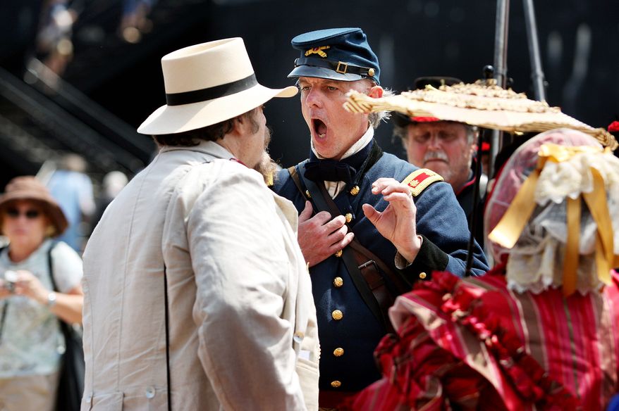 Hours from the re-creation of the bombardment of Fort Sumter, re-enactors' tensions run high as Mark Silas Tackitt of Seattle, who plays Maj. Robert Anderson, commander of Fort Sumter, has fort visitor Major Heros Von Borcke, who is dressed as Confederate sympathizer, tossed from the fort -- at musketpoint -- until he removed a Jefferson Davis button from his lapel, on Monday, April 11, 2011, in Charleston, S.C. (AP Photo/The Post and Courier, Grace Beahm)