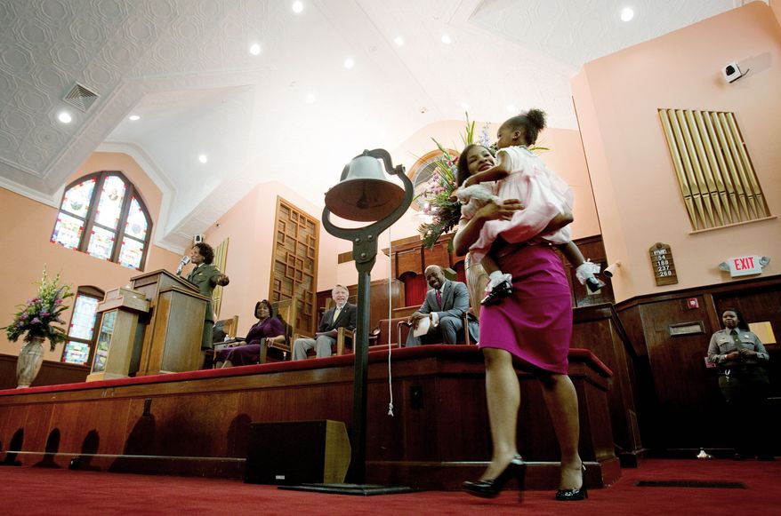 Yolanda King, 3, the only grandchild of the Rev. Martin Luther King Jr., and her mother, Arndrea King, rang a liberty bell at Friday's re-opening ceremony for the restored sanctuary at historic Ebenezer Baptist Church in Atlanta. (Associated Press)