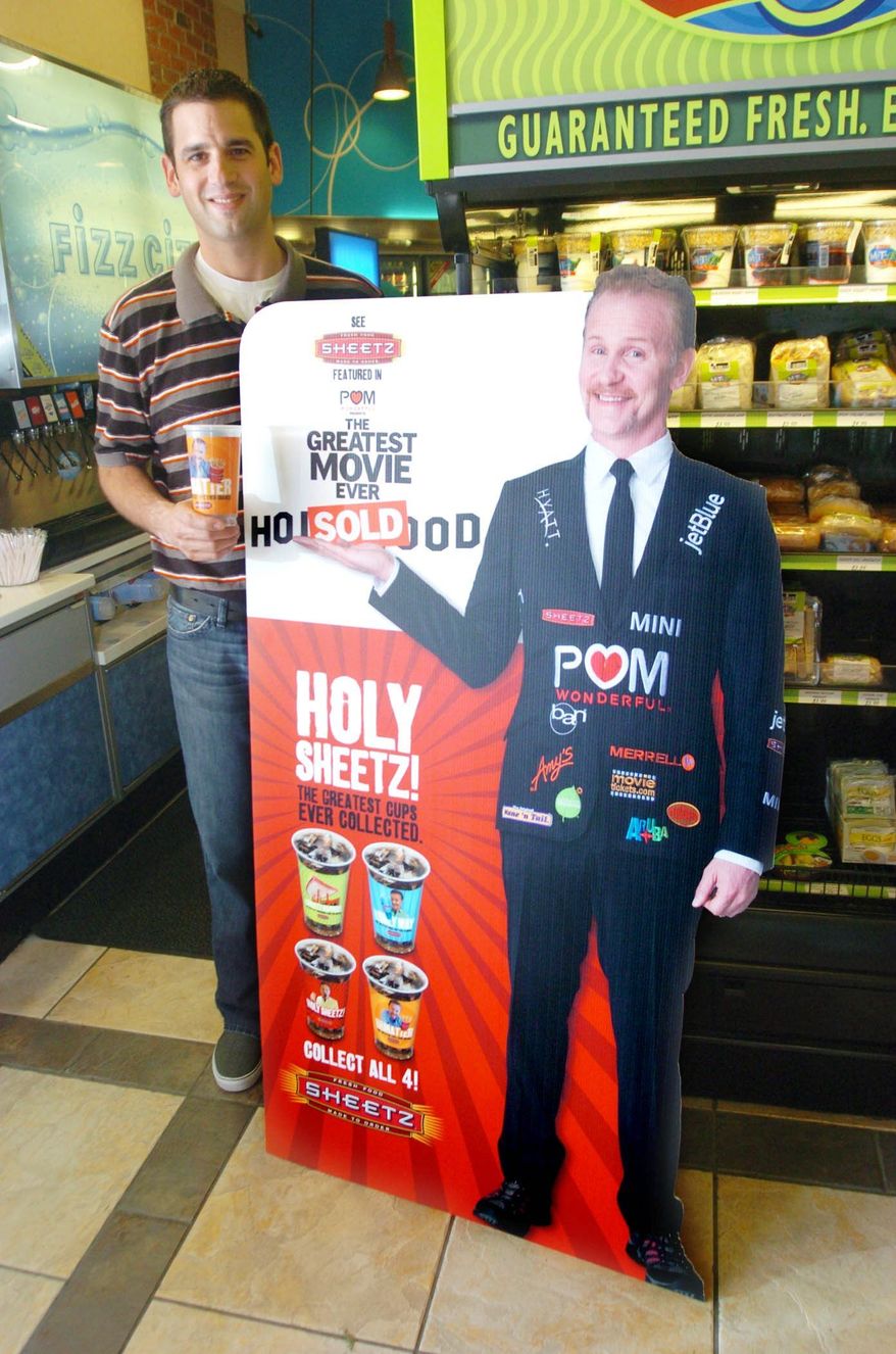 ASSOCIATED PRESS
Filmmaker Morgan Spurlock's image appears on Sheetz collector's cups as part of the promotion of the new documentary, "POM Wonderful Presents: The Greatest Movie Ever Sold." The convenience store chain is a key sponsor of the film.ASSOCIATED PRESS
Fred McConnell, the Sheetz director of brand development, poses with a cutout of filmmaker Morgan Spurlock at a Sheetz location in Altoona, Pa. The city is changing its name to "POM Wonderful Presents: The Greatest Movie Ever Sold" as part of the marketing campaign for Mr. Spurlock's new documentary.