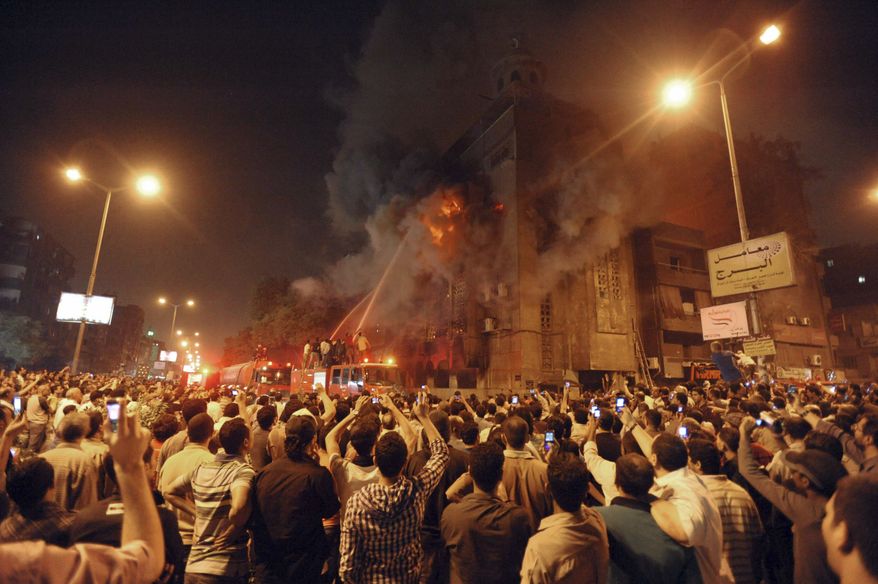 Firemen battle a fire at a church surrounded by angry Muslims in the Imbaba neighborhood in Cairo late on Saturday, May 7, 2011. (AP Photo)