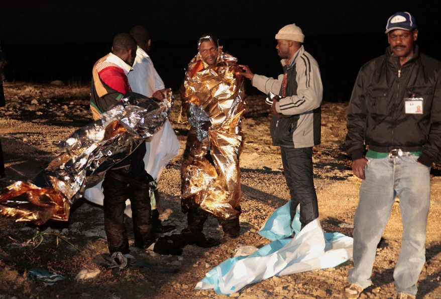 Migrants receive assistance as they arrive on the tiny Italian island of Lampedusa early on Sunday, May 8, 2011. Italian police and coast guard officials rescued some 400 migrants from Libya whose boat was tossed against rocks near the port in southern Italy after the steering malfunctioned, officials said. Tens of thousands have fled unrest in North Africa since January, most arriving at Lampedusa, the nearest Italian port to Africa. (AP Photo/Francesco Malavolta)