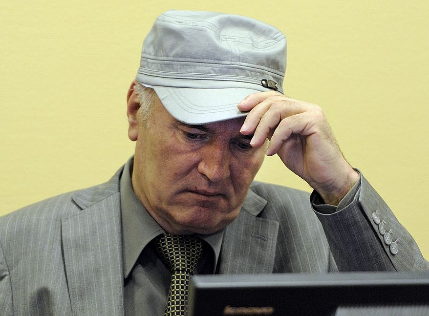 Former Bosnian Serb Gen. Ratko Mladic removes his hat in the courtroom during his initial appearance at the Yugoslav war crimes tribunal in The Hague on Friday, June 3, 2011. (AP Photo/Martin Meissner, Pool)