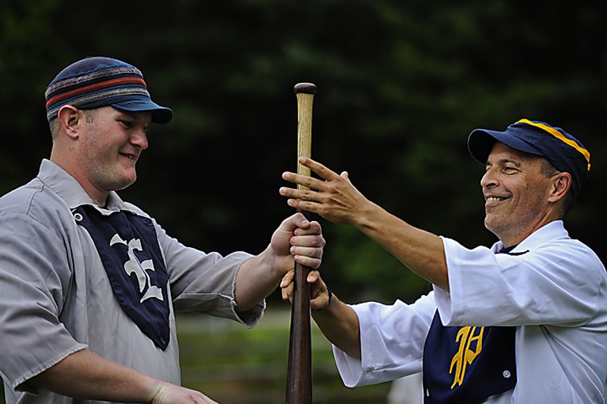 Elkton Eclipse outfielder Glyn "Hammer" Richards, left, of Mt. Ephraim, N.J., and Potomac Nine pitcher J.D. "Buckeye" Almond, of Marshall, Va., at right, do the "bat toss" before the start of a game during the Loudoun Preservation Society's 19th Century Baseball Day at the Oatlands, in Leesburg, Va., Sunday, June 12, 2011. The bat toss is one of unique parts of 1860s era baseball. Instead of the home team always taking the field first (often in this era the teams had no "home" or "away" field), they did an activity called the bat toss. The players start with their hands at the bottom of the bat and alternate their hands up the bat and whichever player gets to the top first and is able to cup the knob wins. The winner of the bat toss chooses if his team will field or hit first. (Drew Angerer/The Washington Times)