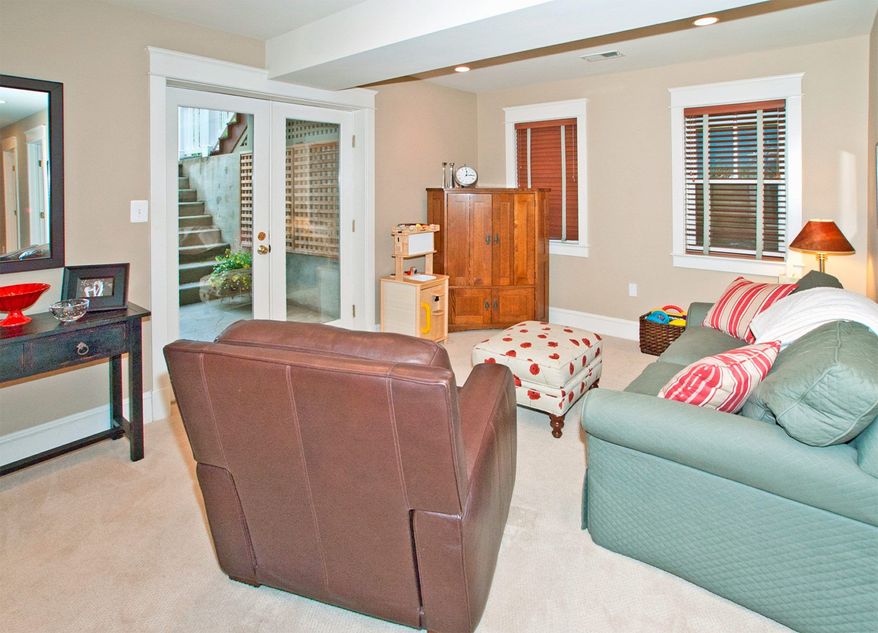 The lower-level recreation room has glass doors that open to steps leading to the flagstone patio and backyard.