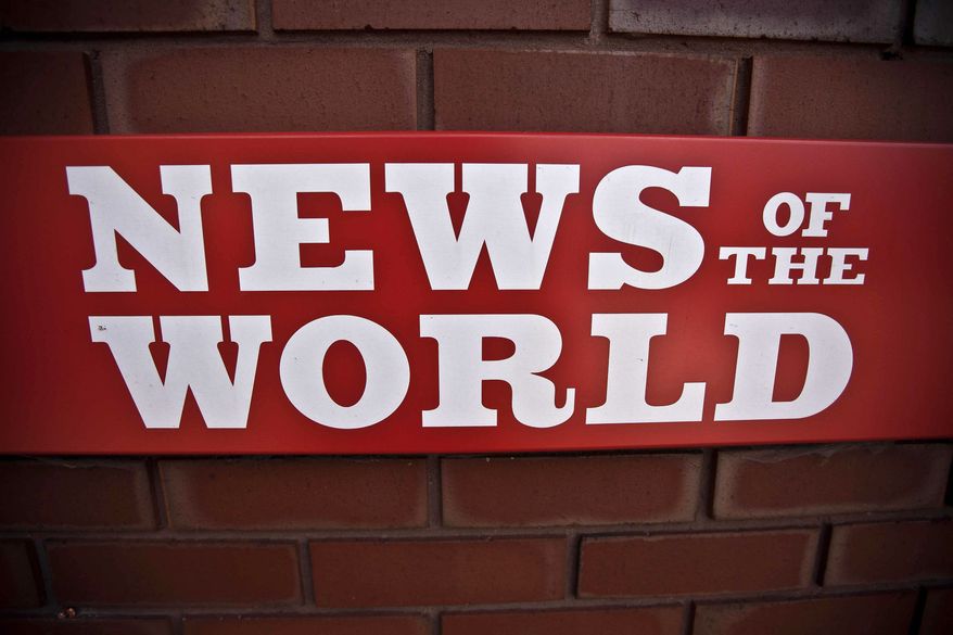 ** FILE ** A News of the World sign is seen by an entrance to a News International building in London on July 6, 2011. (Associated Press)