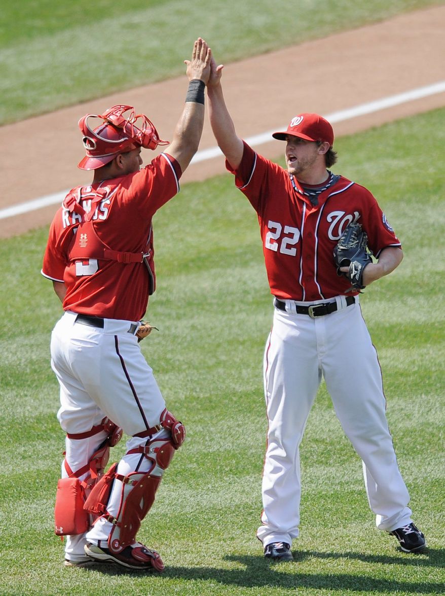 Closer Drew Storen (22) and catcher Wilson Ramos celebrate after the Nationals won 2-0 to avoid a three-game sweep by the Rockies. Washington is 46-46 at the All-Star break. (Associated Press)
