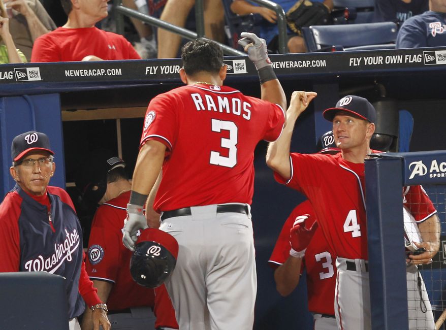 Washington Nationals' Wilson Ramos is greeted at the dugout after hitting a two-run home run in the sixth inning against the Atlanta Braves. Washington won 5-2. (AP Photo/John Bazemore)