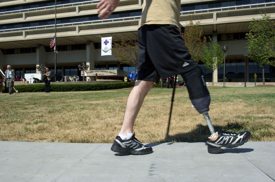 ** FILE ** In this July 27, 2011, file photo, a wounded warrior walks along a sidewalk at Walter Reed during the ceremony to "case the colors" as the wounded and the staff moved to Bethesda or Fort Belvoir. American soldiers "lost their arms and limbs, but thanks to you they never lost themselves." Secretary of the Army John McHugh told the staff. (Barbara L. Salisbury/The Washington Times)