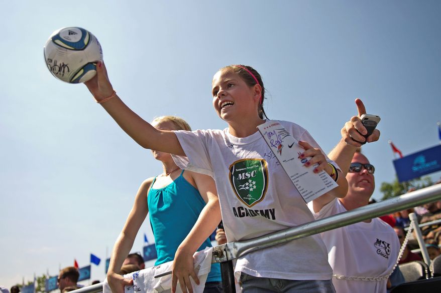 Hoping for an autograph, Isabella Varea of Bethesda extends a ball toward U.S. Soccer player Heather O'Reilly during a charity soccer match Sunday in the District.