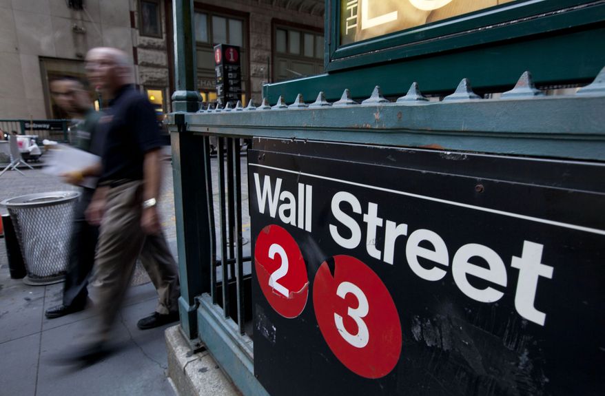 **FILE** Pedestrians walk past a Wall Street sign near the New York Stock Exchange. (Associated Press)