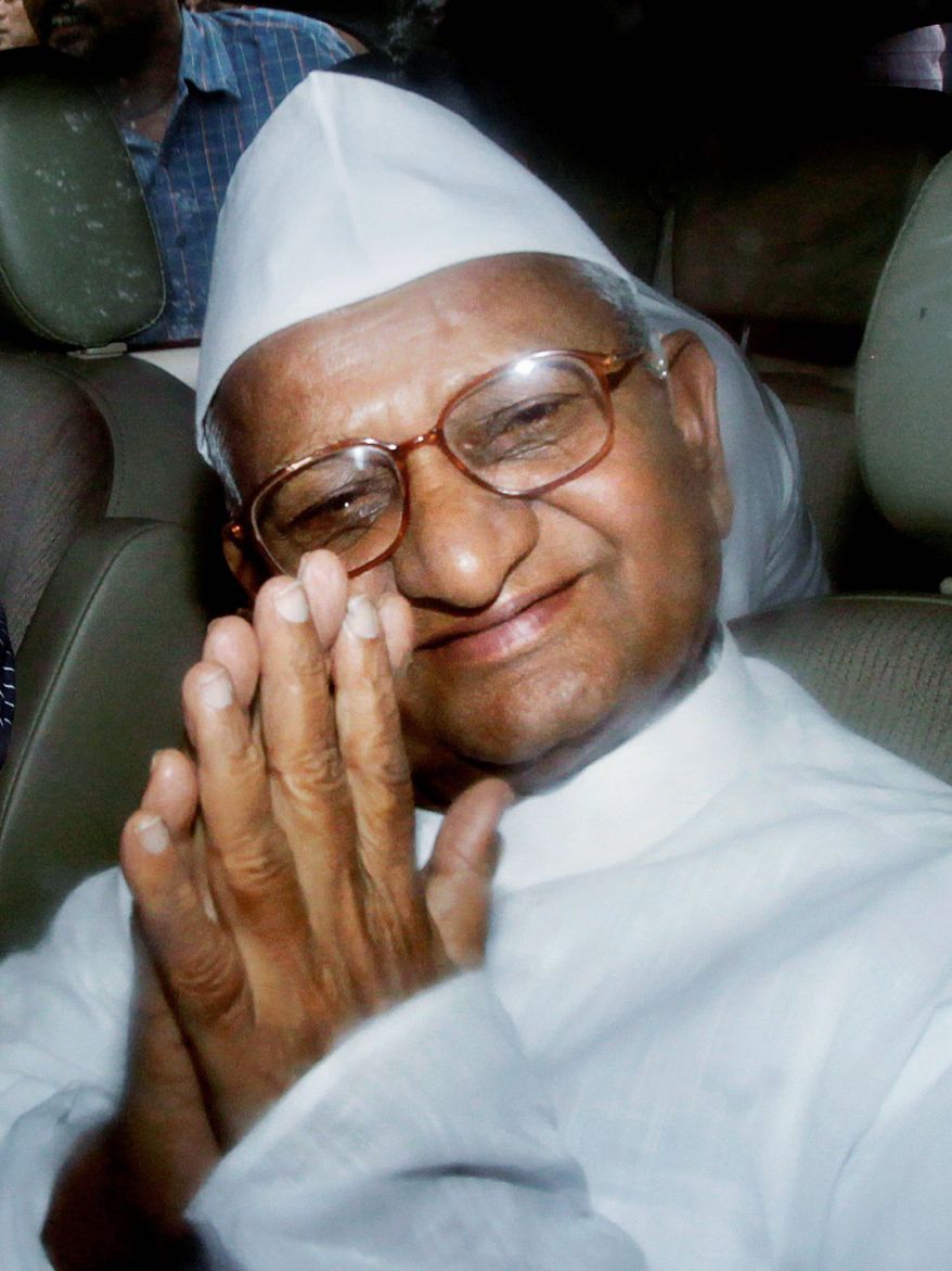 Anna Hazare gestures to supporters from the back of a police van after he was detained prior to beginning a hunger strike on Tuesday.
