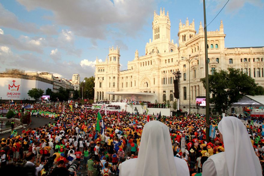 Worshippers join Pope Benedict XVI, on the stage at center, in a prayer at Madrid's Cibeles square Thursday Aug. 18, 2011. The Pope arrived Thursday for a four-day visit to celebrate World Youth Day. (AP Photo/Armando Franca)