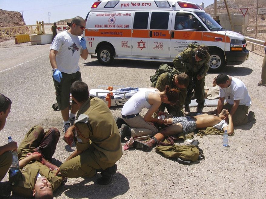 ** FILE ** Wounded Israeli soldiers are treated at the site of a shooting attack along the border between Israel and Egypt, southern Israel, Thursday, Aug. 18, 2011. (AP Photo/Yosi Ben)