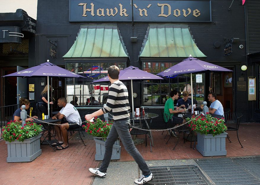 Patrons eat out on the sidewalk patio of the Hawk 'n' Dove bar in Capitol Hill on Wednesday, Aug. 31, 2011. After more than 40 years in business, the bar, which has been an institution on Capitol Hill will be closing down Oct. 2. There will be a series of events and celebrations leading up to the closing, and all of the bar's contents will be auctioned off. Regular patrons told The Washington Times that they are saddened by the closing. Many consider it a home away from home where they gather with friends. (Barbara L. Salisbury/The Washington Times)