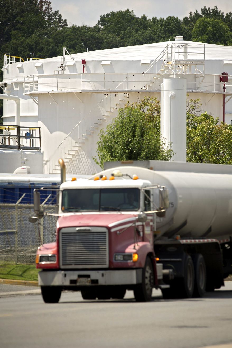 ROD A. LAMKEY/THE WASHINGTON TIMES
A tanker truck rolls by a storage tank at the Transmontaigne facility at the Pickett Road tank farm in Fairfax. Federal and state agencies fined Transmontaigne about $114,000 after two spills in 2010.
