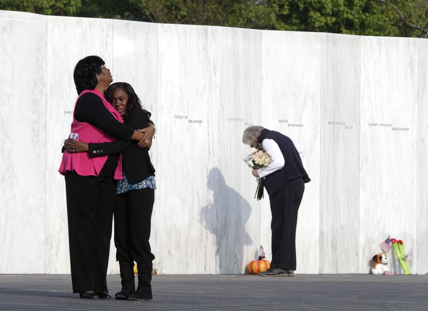 Visitors embrace in front of the Wall of Names near the crash site of Flight 93 in Shanksville, Pa., on Sunday, Sept. 11, 2011. (AP Photo/Amy Sancetta)