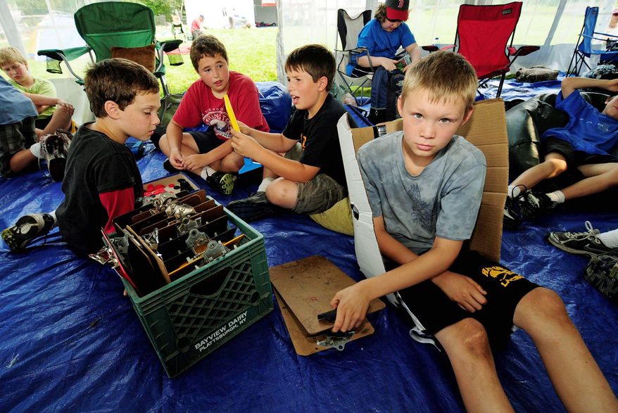 Associated Press
Sixth-grader Colin Green, 11, grabs a clipboard for his next class Sept. 13 inside a tent "classroom" at Moretown, Vt., Elementary School. Flooding damage was estimated at more than $300,000.